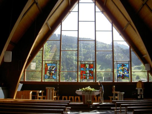 Intérieur de l'Eglise catholique des Diablerets avec cette belle baie vitrée donnant sur la forêt alentour